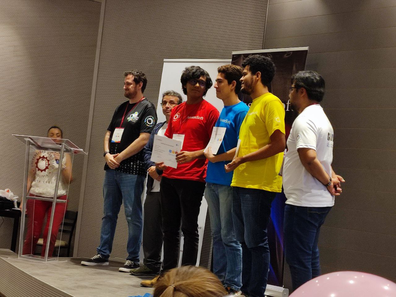 Another team on stage with their certificates at the closing ceremony